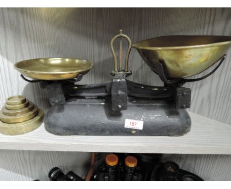 A vintage balance scale set with brass cast weights