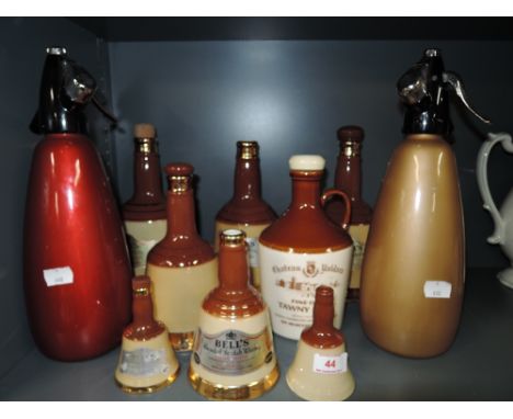 A selection of vintage ceramic Whiskey decanters and soda syphons