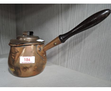 A vintage copper chocolate pot with ebonised handle