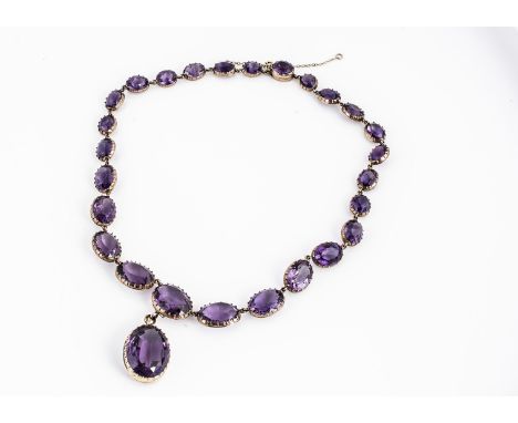 A late 19th early 20th century amethyst and gold necklace, oval mixed cut stones in claw settings graduated strung, with oval