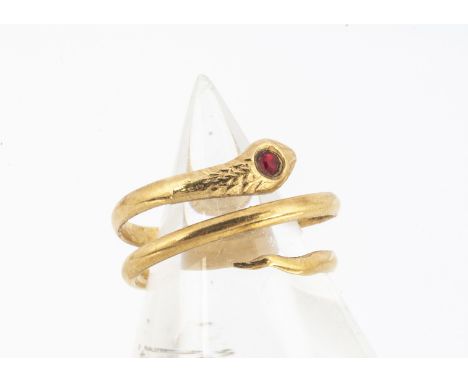 A continental yellow metal serpent ring, of Middle Eastern origin, with red paste stone set head, ring size G1/2, 1.9g