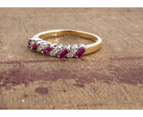 An 18ct gold ruby and diamond dress ring, the five baguette cut rubies, alternately set with pairs of brilliant cut diamonds,