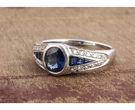 A continental white metal sapphire and diamond Art Deco style dress ring, oval mixed cut sapphire in a rubbed over setting, w