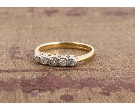 An 18ct yellow gold and platinum set five stone diamond ring, eight cut diamonds in rubbed over setting, on a plain gold shan