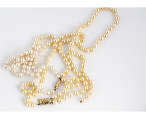 A double row of uniform cultured pearls, knotted strung with 9ct gold clasp, 6.6mm diameter, 45g, af together with a string o