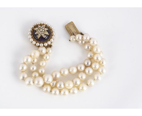 A three strand cultured pearl and garnet clasped bracelet, the knotted strands with larger pearls to centre, having a large c