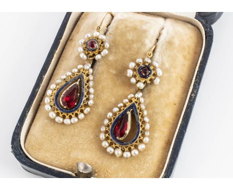 A pair of late 19th century French enamel, seed pearl and gem set ear drops, of oval shape with pear cut red paste centres wi
