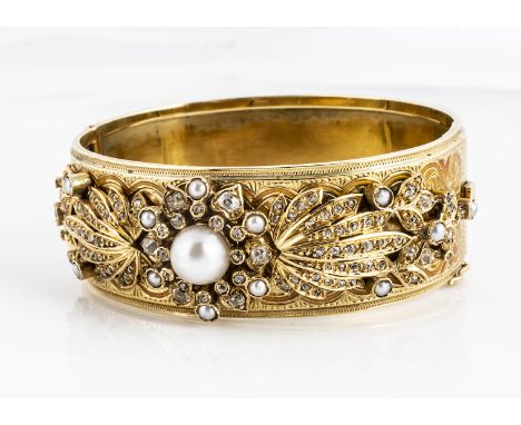 A French marked yellow metal enamel, diamond and seed pearl bangle, the thick bangle, centre set with a half cut blister pear