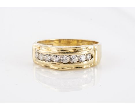 A continental yellow metal and cz set dress ring, channel set with shaped outline, marked 750 to inner shank, ring size S, 5.