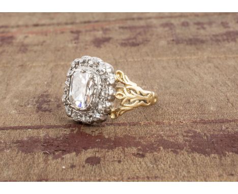 A certificated diamond cluster ring, the central cushion cut diamond surrounded by a bezel of old mine cut diamonds, set in p