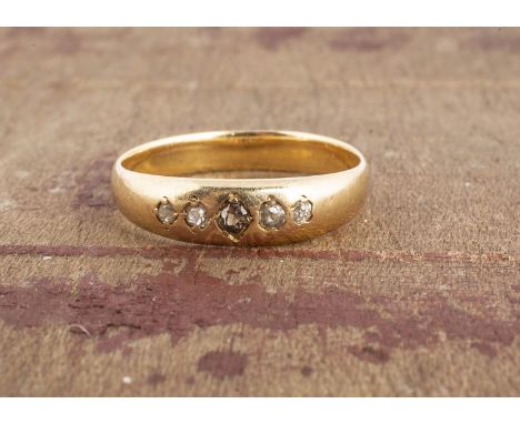 An early 20th century old cut five stone diamond dress ring, centred with a coloured brown diamond,  sunken set either side o