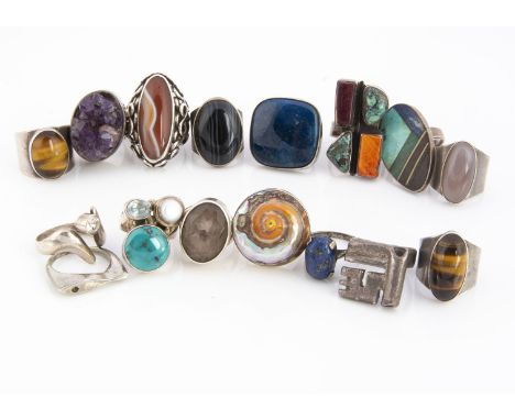 A collection of white metal rings, set with gems and enamel, including amethyst, blue jasper, turquoise, shell and others 194