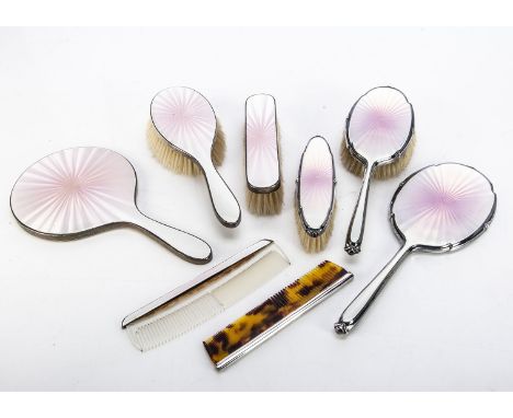 Two early 20th century silver and enamelled dressing table sets, with similar pink coloured guilloche enamel backs, each with