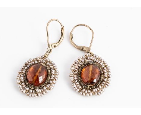 A pair of amber and seed pearl ear drops,  oval shape centred with a faceted amber bead, surrounded by a bezel of seed pearls
