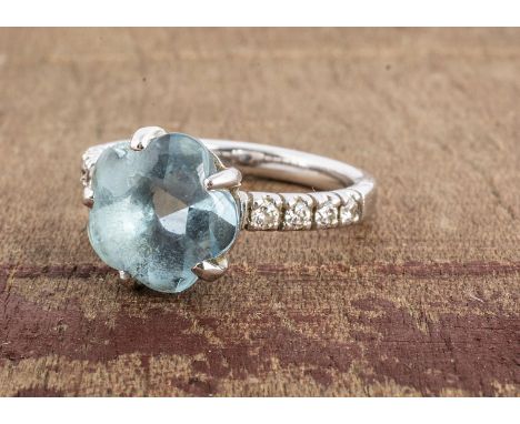 A continental white metal topaz and diamond set dress ring, the mixed flower cut blue topaz, with brilliant cut diamond set s