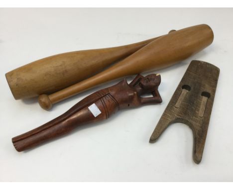 A pair of exercise clubs, circa 1930s/40s, an unusual wooden 'nude' carved nut cracker and boot pull