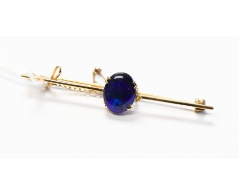 A black opal and 9ct gold bar brooch, the black opal displaying blue and green play of colour, approx 11mm x 9mm, total lengt