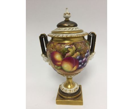 A Royal Worcester fruit painted pedestal vase, having twin handles with mask decoration and cover, signed A Kendry 