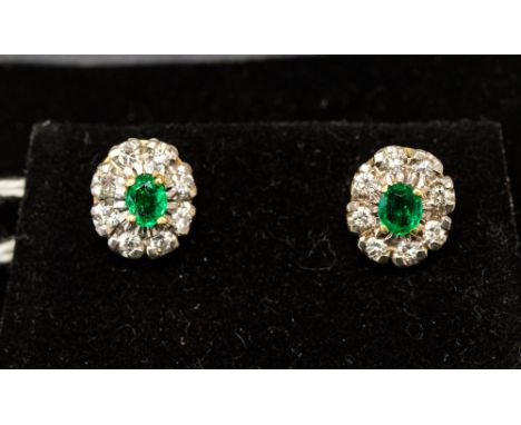 A pair of emerald and diamond earrings set in yellow gold, set with oval emeralds approx 4mm x 3mm, with a diamond surround, 