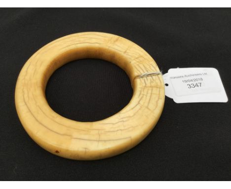 An African tribal bangle, 19th Century, probably The Sudan, carved ivory, approx 11.5cms diameter