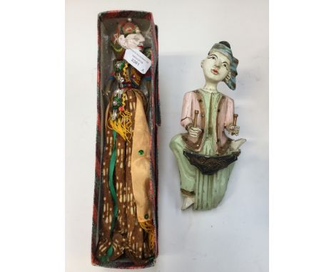 A Balinese wall hanging figurine; together with a puppet in batik printed costume (2) 