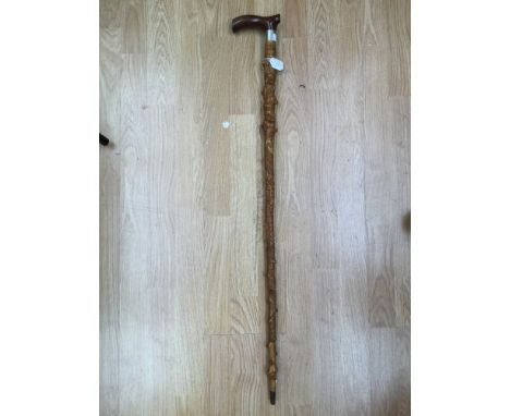 An Edwardian carved hardwood walking stick depicting snakes, woodpecker, fox, squirrel, lizard, etc and woodland foliage, ins