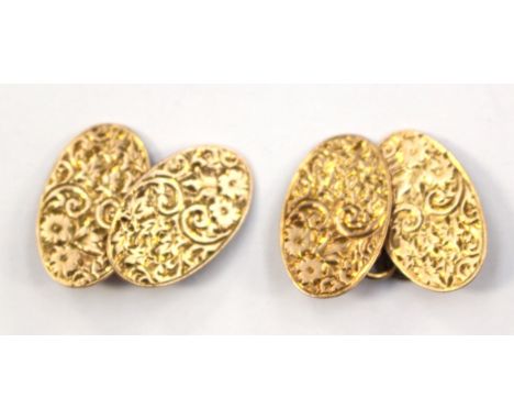 A pair of cufflinks with oval detail, engraved with foliate pattern 