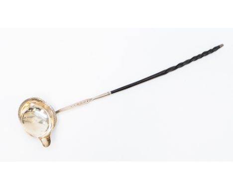 A George III silver bright cut engraved Toddy ladle with whale bone twist handle, the reverse handle engraved with crest & mo