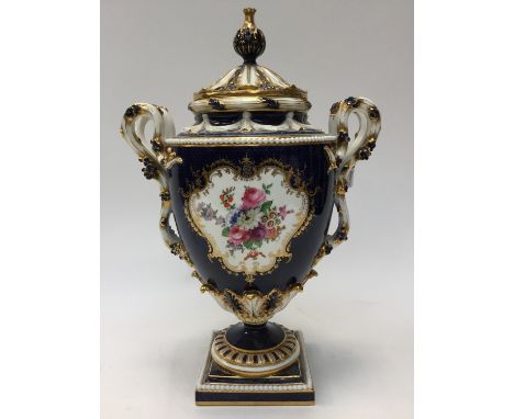 A large Royal Worcester molded and elaborate twin handled pedestal vase and cover, having cobalt blue fish scale ground, with