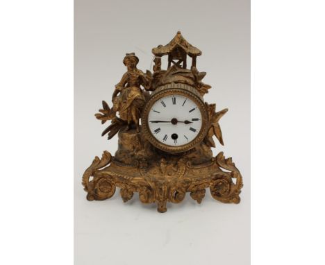 A Victorian gilt spelter mantle clock, with a white enamelled dial, black Roman numerals, the clock with a figure to one side