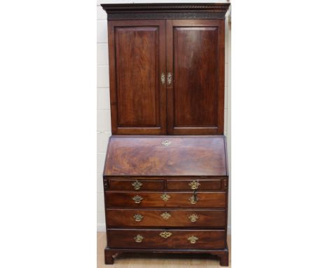 A George III mahogany bureau bookcase, in the Chippendale manner, the cornice with a blind fretwork frieze, fitted with two c