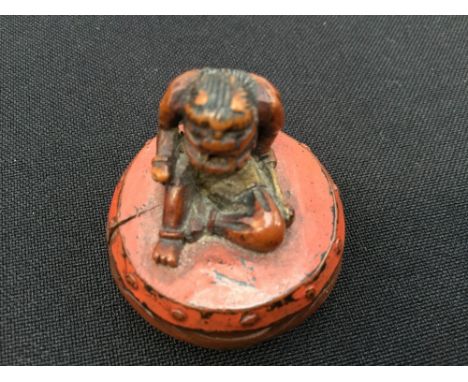 A Japanese Meiji period carved and lacquered boxwood netsuke of Raijin the Thunder God seated on drum, late 19th Century/earl