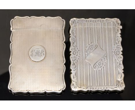  A Victorian silver shaped rectangular card case, engraved with striated and engine turned decoration with a band of scrollin