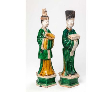 A PAIR OF CHINESE SANCAI-GLAZED POTTERY FIGURES OF ATTENDANTS, MING DYNASTY, 1368-1644 Each standing on a hexagonal base, wea
