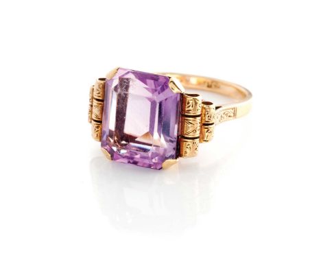 AN AMETHYST RING Claw set to the centre with an emerald-cut amethyst weighing approximately 5.17ct, the shoulders with engrav