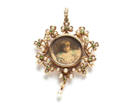 A VICTORIAN SEED PEARL AND PERIDOT PORTRAIT PENDANT Designed as a wreath of shamrocks and scrolls and centred with a circular