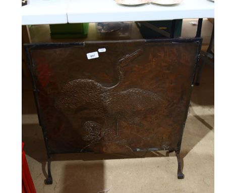 A fire screen with embossed copper panel, depicting a stylised bird, height 65cm 
