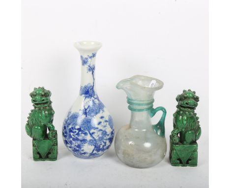 A Japanese blue and white porcelain bottle vase, a pair of Chinese green glaze Dogs of Fo, and a Roman iridescent glass jug, 