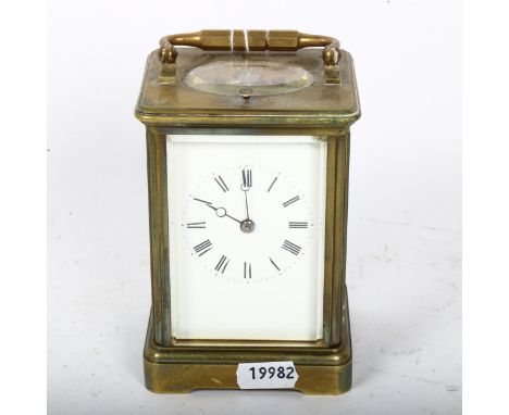 A brass repeating carriage clock, white enamel dial with Roman numeral hour markers and movement striking on a gong, case hei