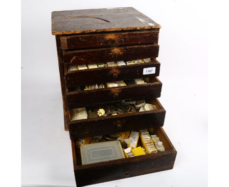 A Vintage watchmaker's table-top chest of drawers, containing a large quantity of various parts and spares 