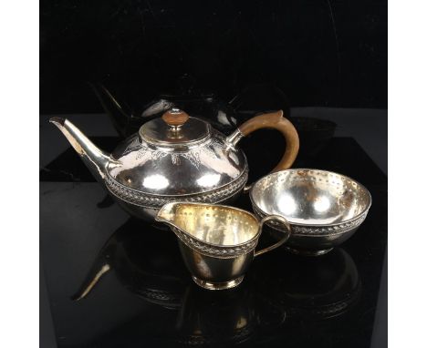 An Arts and Crafts 3-piece silver tea set, squat form with allover planished decoration, and woven waistband with turned moun