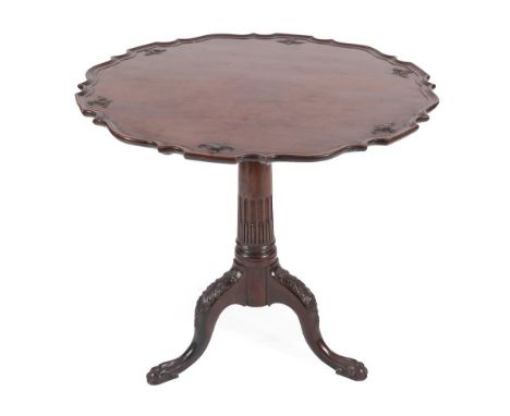 A George III Style Carved Mahogany Tripod Table, the scalloped top above a block support and stop-fluted column, on acanthus 