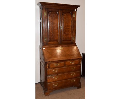 An 18th Century Oak Bureau Bookcase, the moulded cornice above twin panelled doors, shelved interior, quarter canted column c