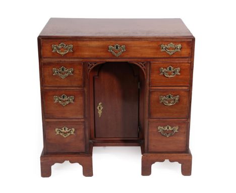 A George III Mahogany and Oak Lined Kneehole Dressing Table, late 18th century, the plain top above a long frieze drawer with