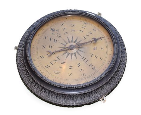 A Brass Weather Vane Dial, 19th century, with steel hand and engraved markings, in a carved ebonised frame, 35.5cm diameter