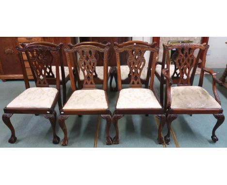 A lot of eight mahogany Chippendale style dining chairs (six regular and two carvers) with carved scroll splats over damask u