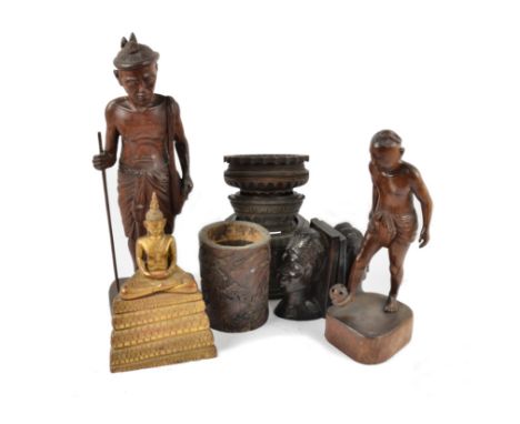 A collection of Middle-Eastern carved wooden figures, including a pair of bookends modelled as faces, a boy playing with a ba