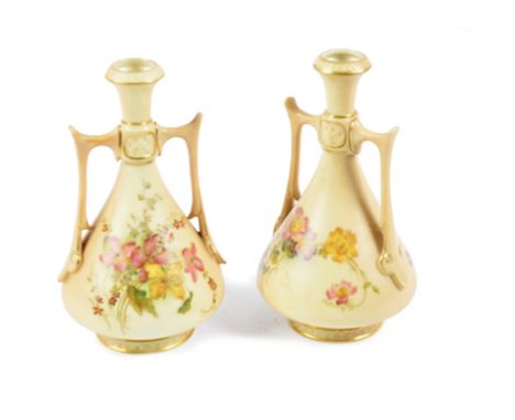 A pair of Royal Worcester twin-handled vases, painted with flowers on a blush ivory ground and gilt highlights, 1906, shape 1