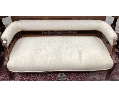 Edwardian mahogany sofa, with pad upholstered back and seat raised on pierced supports and reeded square tapered legs on cast