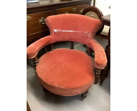 Victorian upholstered tub chair on turned front legs and ceramic castors